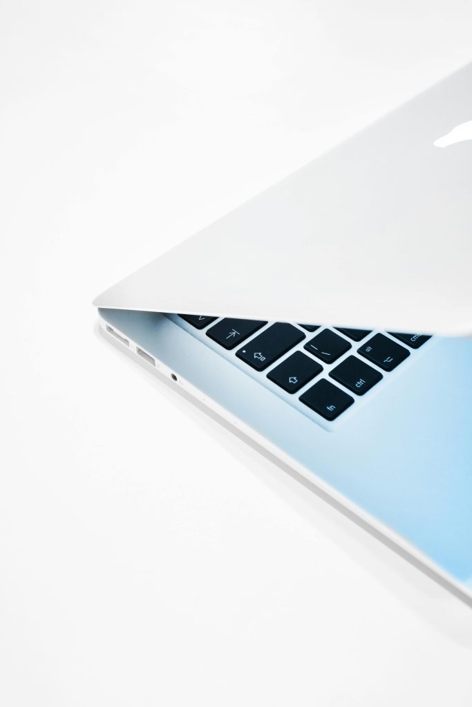 Close-up of a sleek laptop slightly opened on a crisp white background.